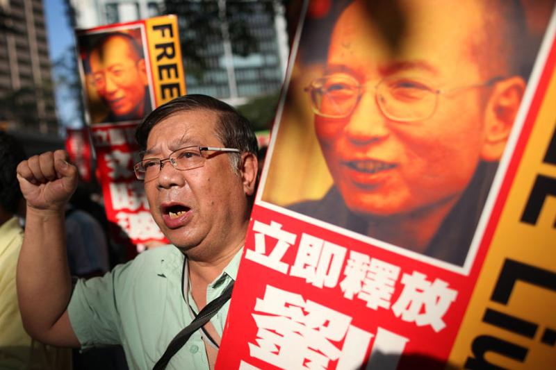 Protesters wave banners and placards as they march through Hong Kong on December 5, 2010, calling for the release of jailed Chinese Nobel Peace Prize winner Liu Xiaobo.