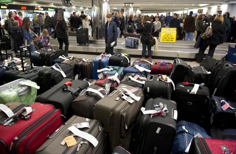 Unclaimed bags in the foreground as travelers retrieve their luggage at New York's LaGuardia Airport on December 28, 2010.