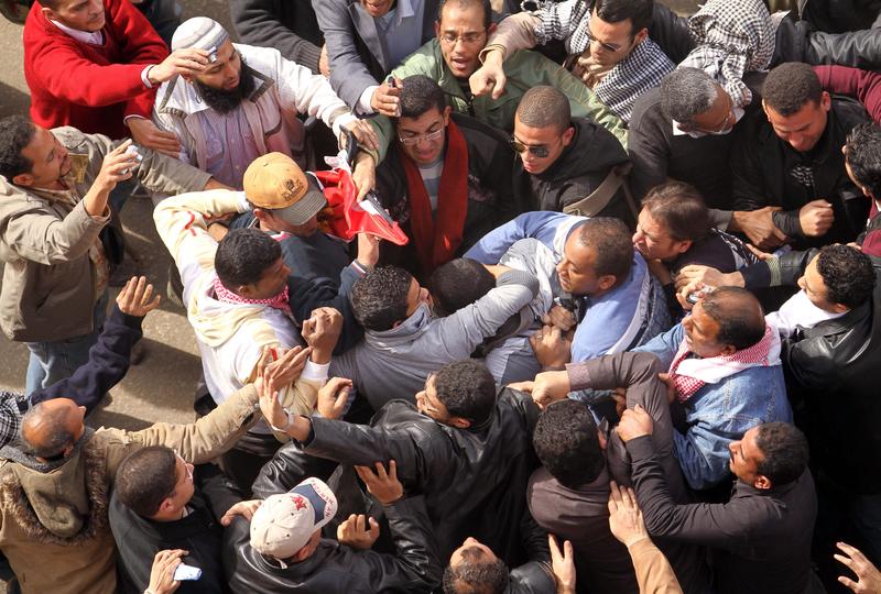 Egyptian protestors opposed to President Hosni Mubarak detain a government supporter during protests on February 3, 2011 near Cairo's central Tahrir Square.