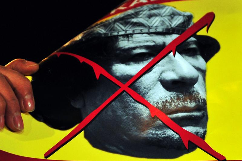 A banner featuring Libyan leader Moammar Gadhafi is seen as demonstrators stage a protest outside the Libyan embassy in Istanbul on February 21, 2011.