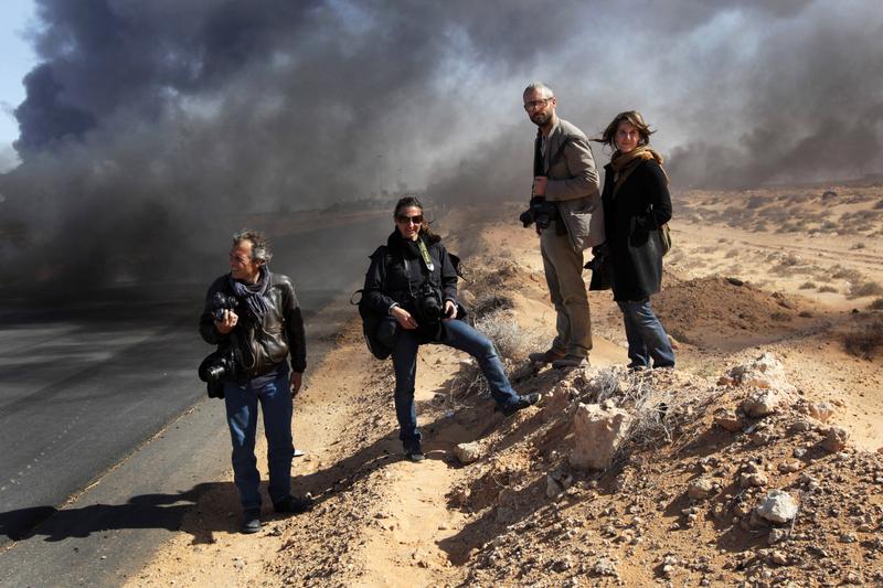 Yuri Kosyrev of Time Magazine, Lynsey Addario and Tyler Hicks of the New York Times and freelancer Nicki Sobecki stand during a pause in the fighting March 11, 2011 in Ras Lanuf, Libya.