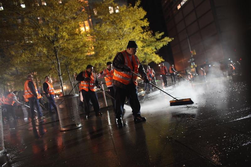 Workers clean up Zuccotti Park after New York City police in riot gear removed Occupy Wall Street protesters early on November 15, 2011 in New York.