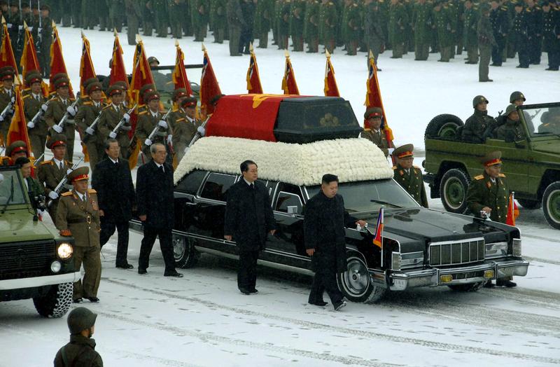 Kim Jong-un (center R) besides the convoy carrying the body of his father and late leader Kim Jong-il at Kumsusan Memorial Palace in Pyongyang on December 28.