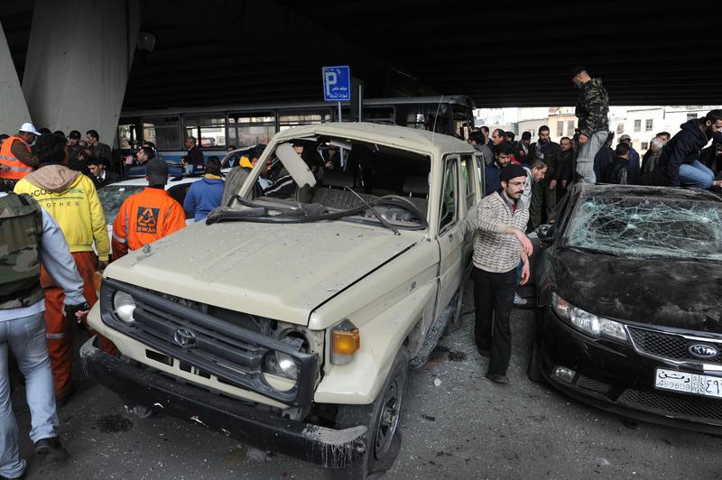 People gather at the site of a powerful explosion that hit the Midan neighbourhood in of Damascus on January 6, 2012 as state media said a suicide bomb attack ripped through the Syrian capital.