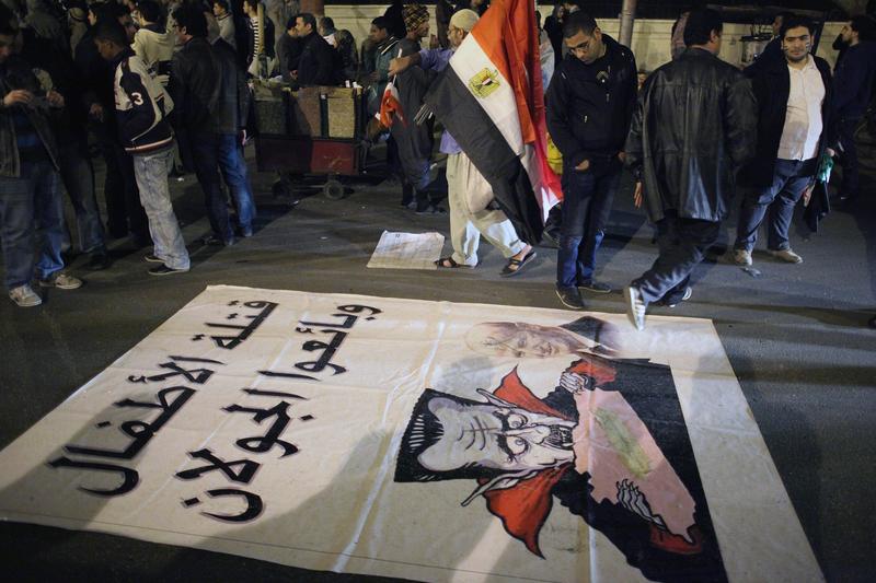 A caricature of Syrian President Bashar al-Assad is spread on the ground as Syrian people demonstrate outside the Arab League building on January 22, 2012 in Cairo Egypt.