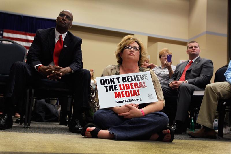 People listen as Republican presidential candidate Newt Gingrich speaks in Jacksonville, Florida.