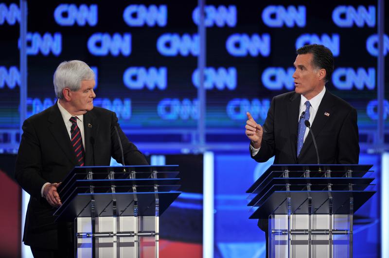 Republican presidential candidates Newt Gingrich listens to former Massachusetts governor Mitt Romney.