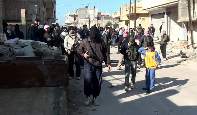 An image taken from YouTube on January 28, 2012 shows armed men, said to be members of the Free Syrian Army (FSA), standing guard during an anti-regime protest in the central town of Rastan.