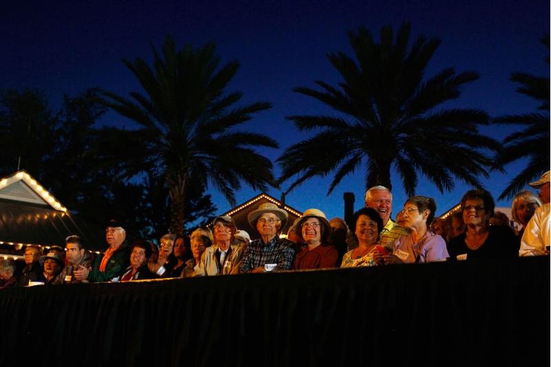 People wait to hear Republican presidential candidate, former Massachusetts Gov. Mitt Romney speak to them during a grassroots rally with supporters at Lake Sumter Landing on January 30, 2012