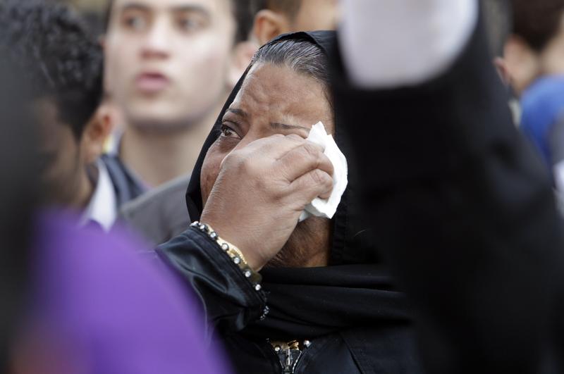 A tearful woman wipes her tears as protesters gather to demonstrate outside Cairo's Al Ahly football stadium.