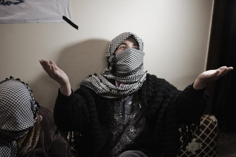 A Syrian woman gestures as she works on flags to be used in a demonstration at a workshop in Qusayr.