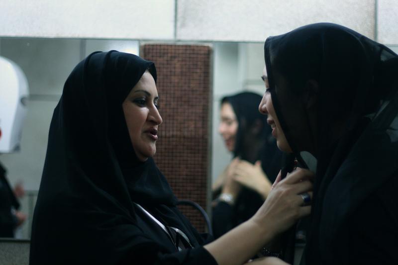 Two women adjust their hijabs in Saudi Arabia.