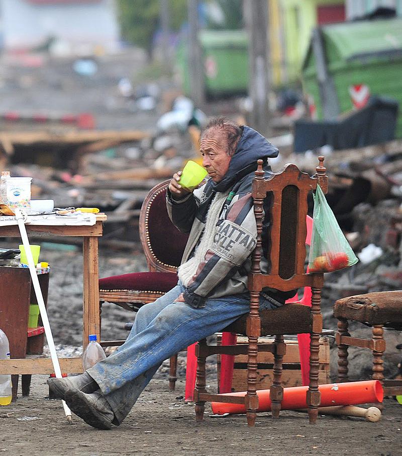 Man drinks in a street devastated by the tsunami in Talcahuano, Chile