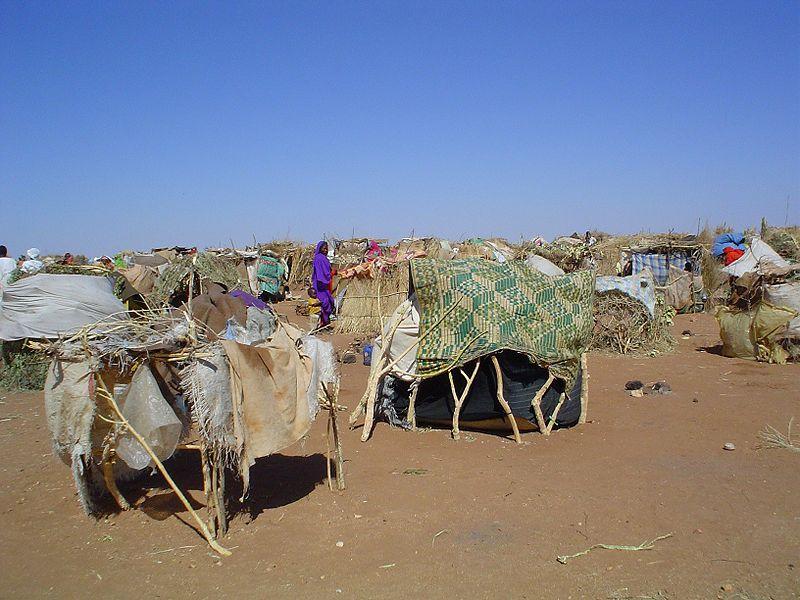 Internally Displaced Persons (IDPs) use sticks and scraps of plastic to construct makeshift shelters at Intifada transit camp near Nyala in South Darfur.