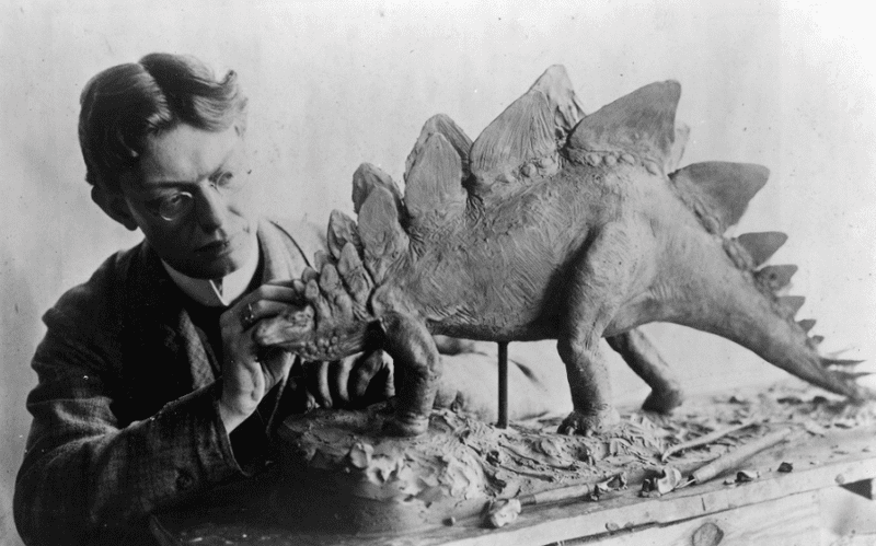 Charles R. Knight at work on a model of a stegosaurus in 1899