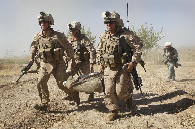 U.S. Marines carry a wounded enemy prisoner of war (EPW) to a MEDEVAC helicopter September 21, 2010 near Marja, Afghanistan.