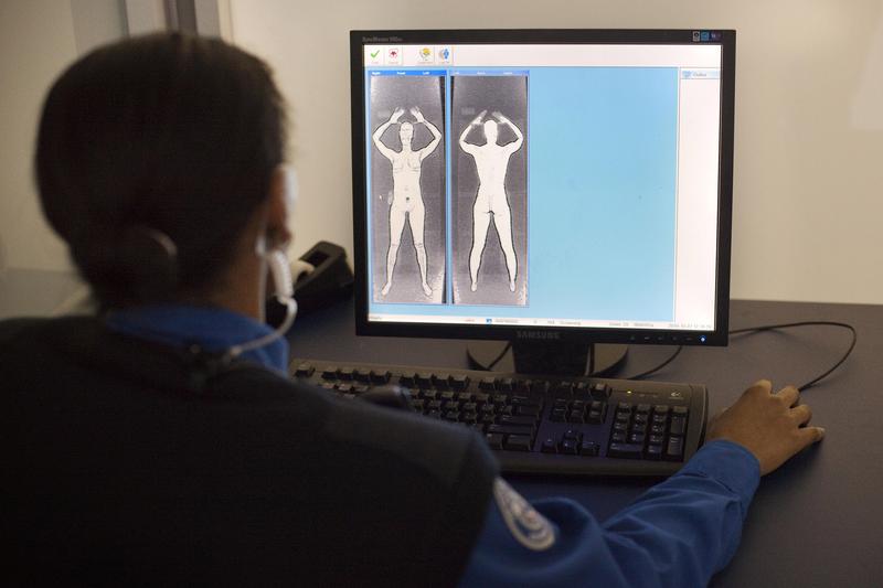 A TSA officer demonstrates what the images from the Advanced Imaging Technology unit look like at John F. Kennedy International Airport's Terminal 8 passenger security checkpoint on October 22, 2010