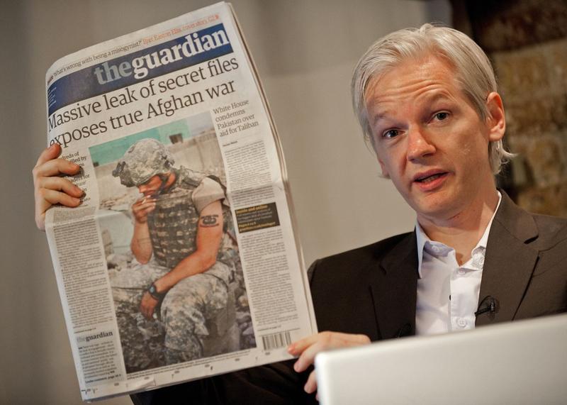WikiLeaks Founder Julian Assange holds a copy of today's Guardian newspaper