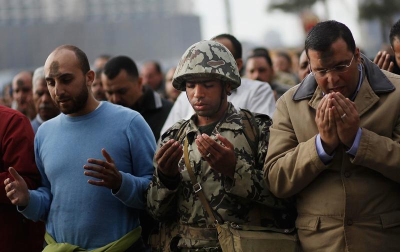 An Egyptian Army soldier prays along with anti-government protesters during the afternoon in Tahrir Square January 30, 2011 in Cairo, Egypt.