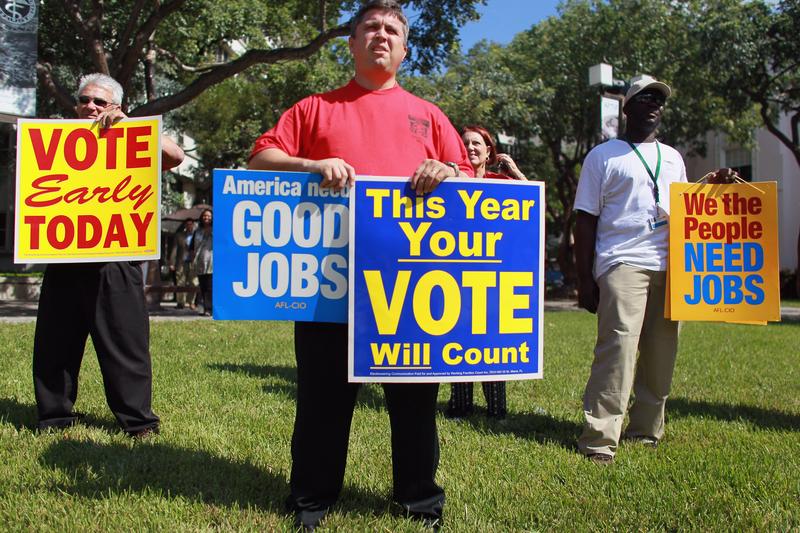 Jason Joseph holds campaign signs during a get out the vote rally put on by local unions and Democratic politicians on the grounds of the Jackson Memorial hospital on October 18, 2010 in Miami, Fla.