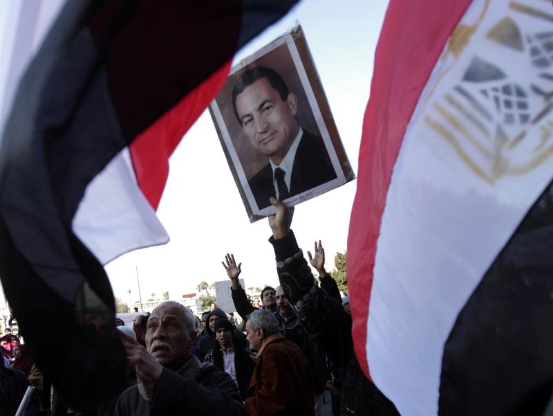 Supporters of President Mubarak wave their national flag as they hold a rally in support of the veteran leader in Cairo on February 2, 2011.