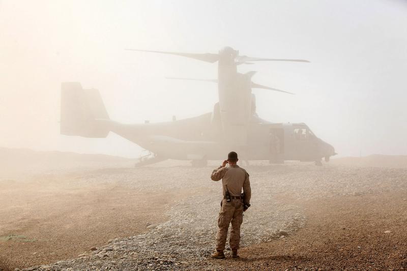 A U.S. Marine watches as an Osprey carrying U.S. Secretary of Defense Leon Panetta arrives March 14, 2012 at Forward Operating Base Shukvani, Afghanistan.