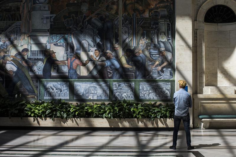 A man looks at a Diego Rivera mural at the Detroit Institute of Arts (DIA) on 9/13/13. As the city government struggles to pay off its debts, some suggest selling off some of the DIA's collection.