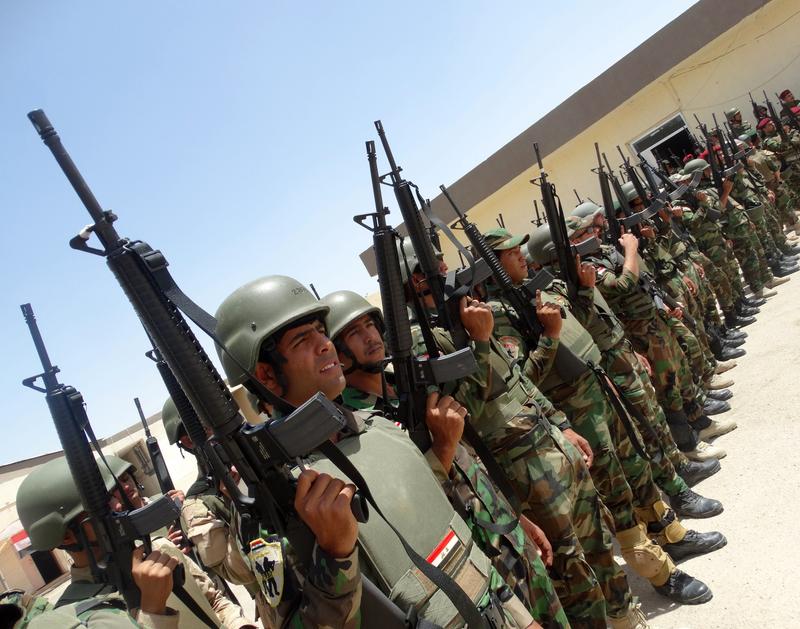 Iraqi troops stand in rows holding their weapons as they arrive to support the Sunni anti-Al-Qaeda militia Sahwa in its fight against anti-government militants. June 21, 2014