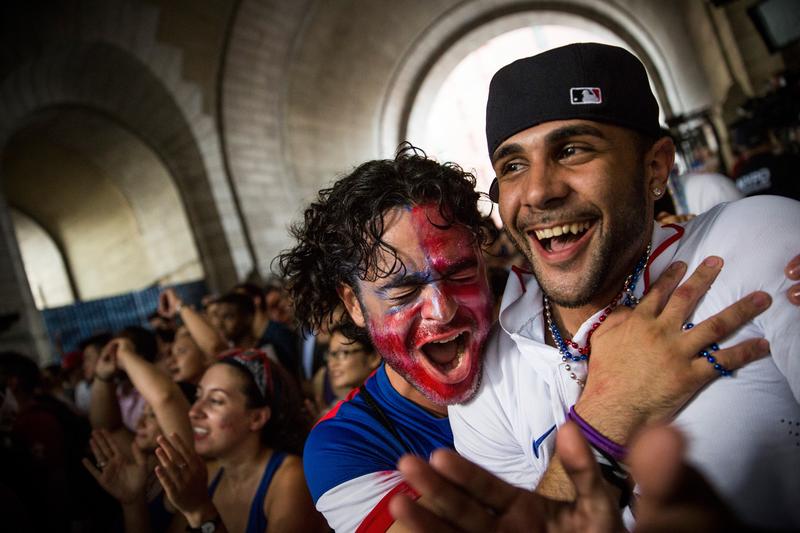 Christian Raja (L), of Brooklyn, reacts while watching the United States versus Belgium game in the World Cup on a projected screen under the Manhattan Bridge on July 1, 2014.