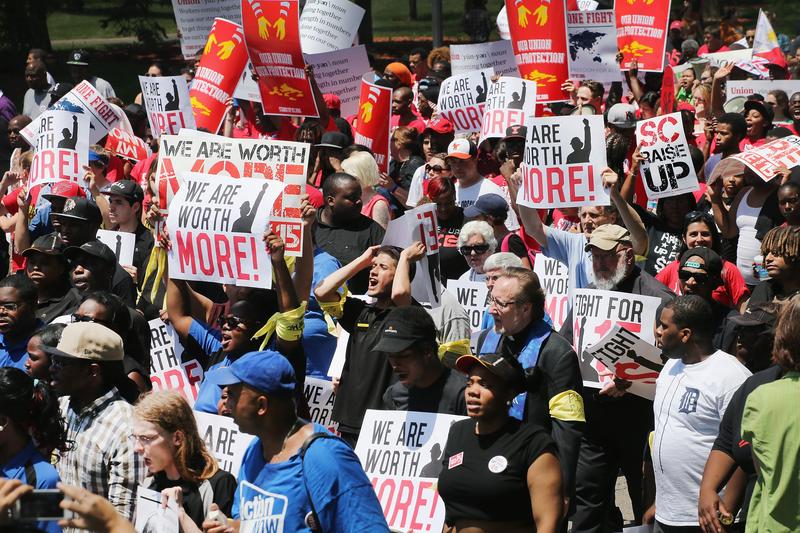 Fast food workers and activists demonstrate outside the McDonald's corporate campus on May 21, 2014 in Oak Brook, IL. Demonstrators were calling on McDonald's to pay a minimum wage of $15-per hour.