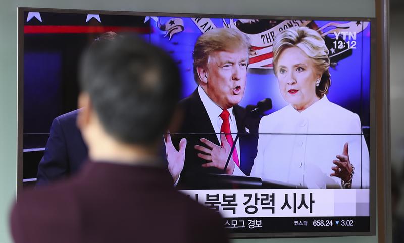 A man watches a TV screen showing the presidential debate between Hillary Clinton and Donald Trump in Seoul, South Korea. October 20, 2016