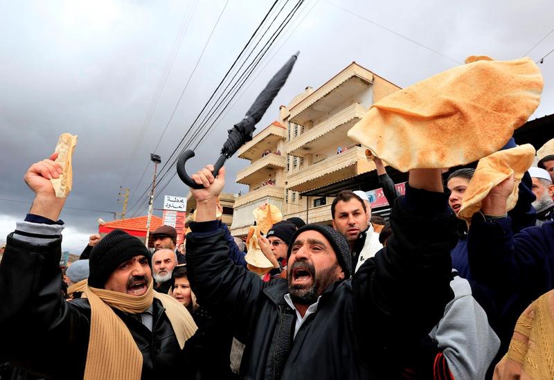 Protesters on the Syrian-Lebanon border hold bread to raise awareness of the situation in Madaya.