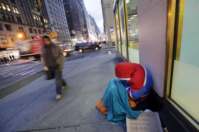 A homeless person sleeps on a New York sidewalk, Wednesday morning, Jan. 14, 2015. The overnight temperature was 17 degrees (- 8C).