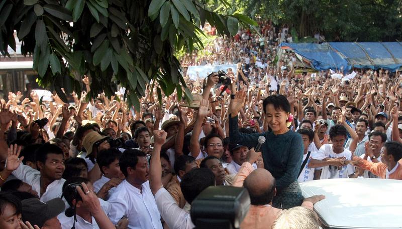 Myanmar's newly-released opposition leader Aung San Suu Kyi (R) waves to the crowd as she arrives at her National League for Democracy (NLD) headquarters in Yangon on November 14, 2010.