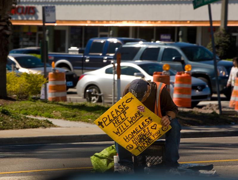 A homeless man sits along the Kennedy Blvd traffic island on February 14, 2011 in Tampa, Florida.