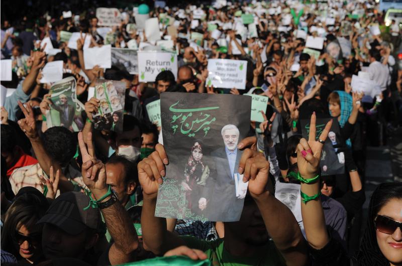 Demonstrators carry banners and pictures of Mir Hossein Mousavi, the defeated reformist candidate, during a march on Karimkhan Street, Tehran, 17th June 2009.