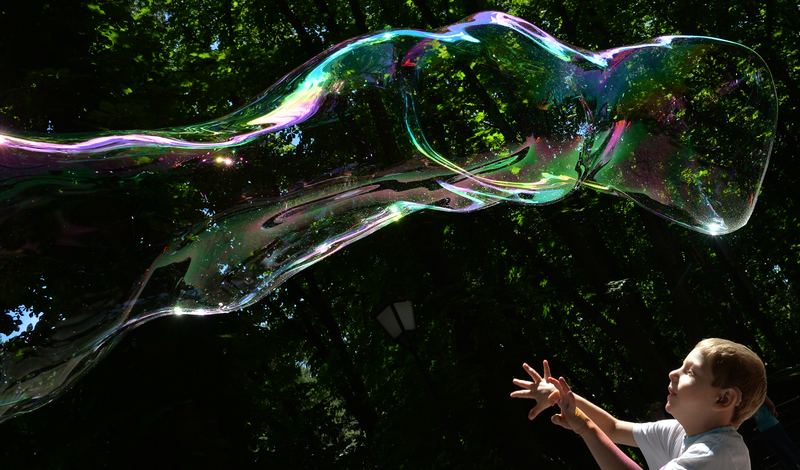 A boy plays on May 28, 2013 with soap bubbles during the Share Drive of Life charity event organized by the Kiev Chapter Ukraine motorcycling club for children with autism in a park in Kiev.