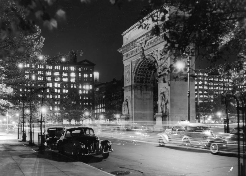 circa 1945: View of the lights of cars at night in front of the Washington Arch in Washington Square Park, Greenwich Village, New York City