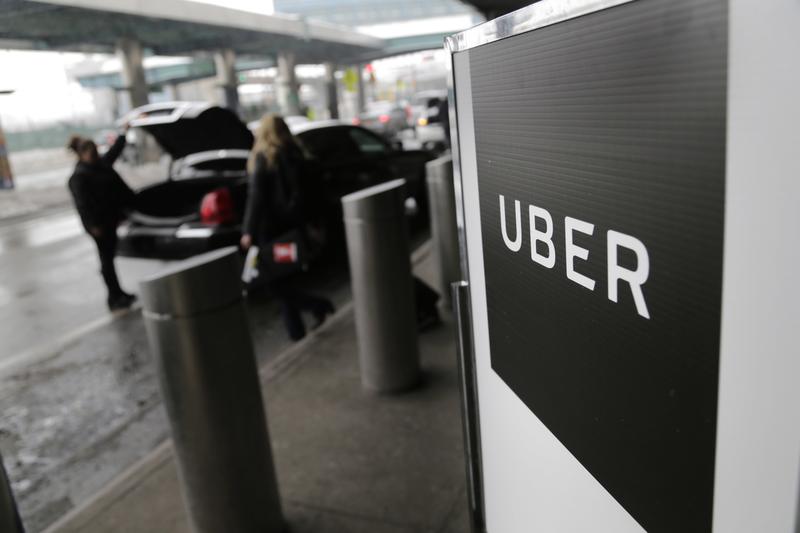 In this March 15, 2017 photo, a sign marks a pick-up point for the Uber car service at LaGuardia Airport in New York.