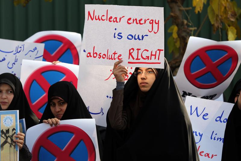 An Iranian student holds a placard reading 'Nuclear energy is our absolute right' during a demonstration outside the Tehran Research Reactor in the capital Tehran on November 23, 2014