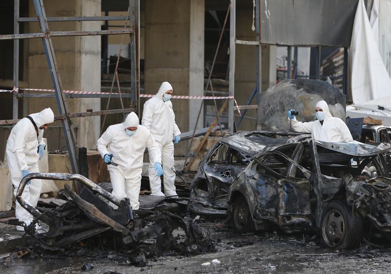 Lebanese forensic experts inspect the scene of a huge car bomb explosion that rocked central Beirut on December 27, 2013, killing Mohamed Chatah (Shatah), former finance minister and others.
