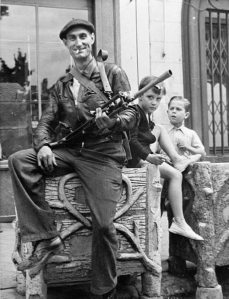 Watched by two small boys, a member of the French resistance (French Forces of the Interior) poses with his Bren gun at Chateaudun in 1944.