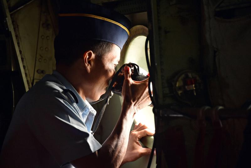 Indonesian Air Force personnel take photos at the water from a C-130 Hercules aircraft over the Java Sea during search and rescue operations for missing AirAsia flight QZ8501 on December 29, 2014. The