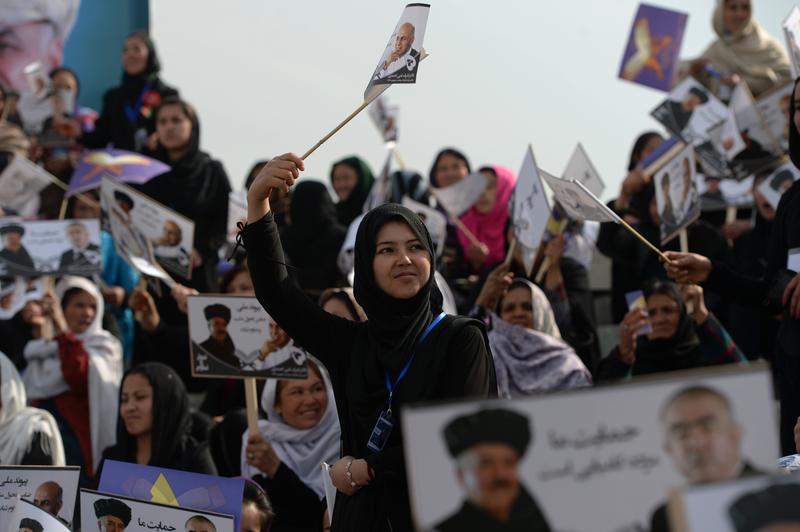 Afghan supporters of presidential candidate Ashraf Ghani Ahmadzai wave flags bearing his image during an election rally at the Ghazi Stadium in Kabul on April 1, 2014.