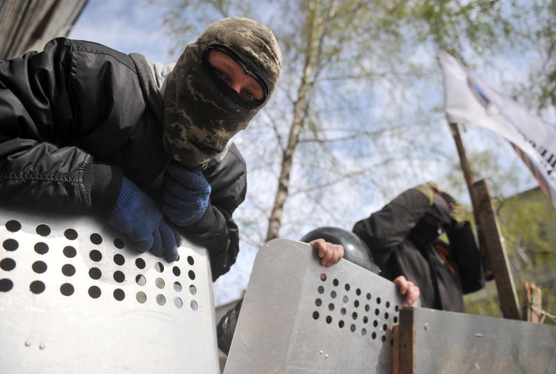 Pro-Russia activists guard a barricade outside the police regional building seized by the separatists in the eastern Ukrainian city of Slavyansk on April 17, 2014.