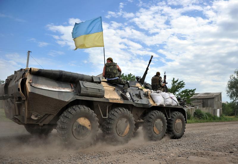 Ukrainian troops drive in Armoured Personnel Carriers through a small village bordering the Kharkiv and Donetsk regions, some 40 kilometers south of Izyum, on May 25, 2014.