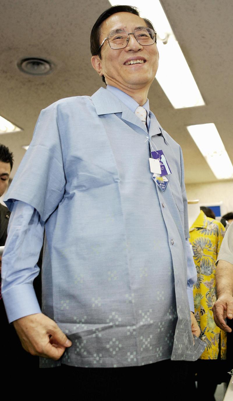 Japanese Chief Cabinet Secretary Hiroyuki Hosoda smiles as he wears a short sleeves shirt to promote the Japanese government's energy saving in summer time by not wearing jackets, 25 May 2005 in Tokyo