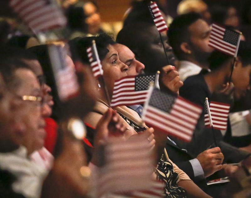 New U.S. citizens wave flags during a special Flag Day naturalization ceremony at the New York Historical Society on Tuesday, June 14, 2016 in New York.