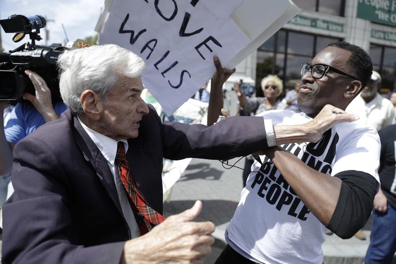 Jerry Lambert, left, a supporter of Republican presidential candidate Donald Trump, and Asa Khalif with Black Lives Matter scuffle, after Khalif took Lambert's sign, outside the location where Trump i