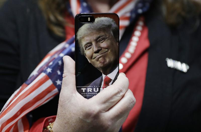 A woman holds up her cell phone before a rally with Republican presidential candidate Donald Trump, Thursday, Sept. 29, 2016, in Bedford, N.H.